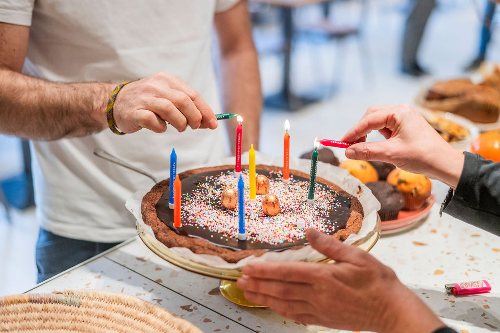 Gâteau d’anniversaire avec des bougies allumées et un décor sucré coloré