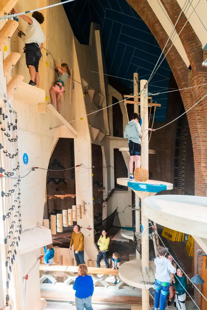 Une salle d’escalade intérieure en bois avec des enfants qui grimpent